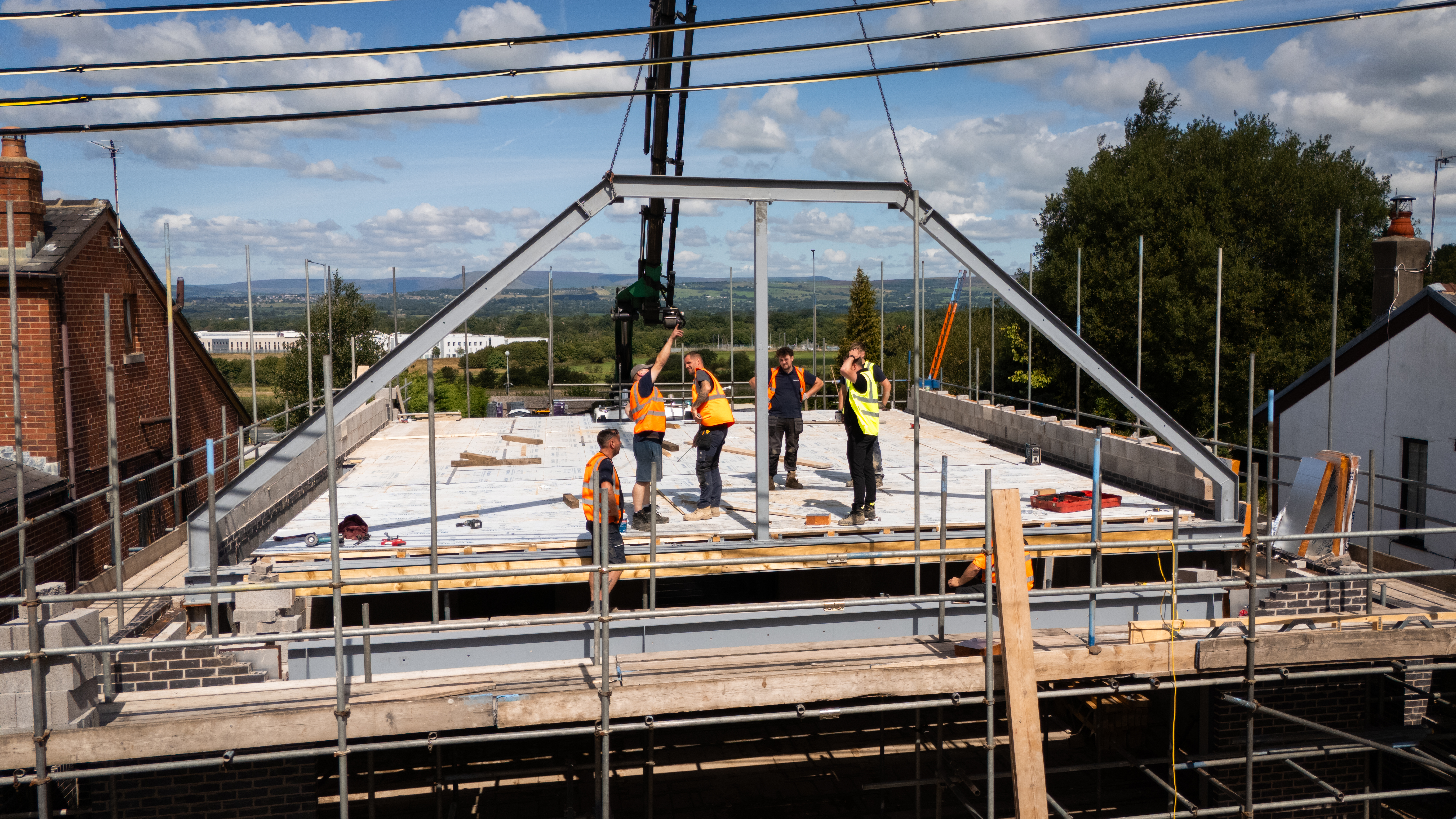 Steel frame roof structure under construction with team on site — Artico