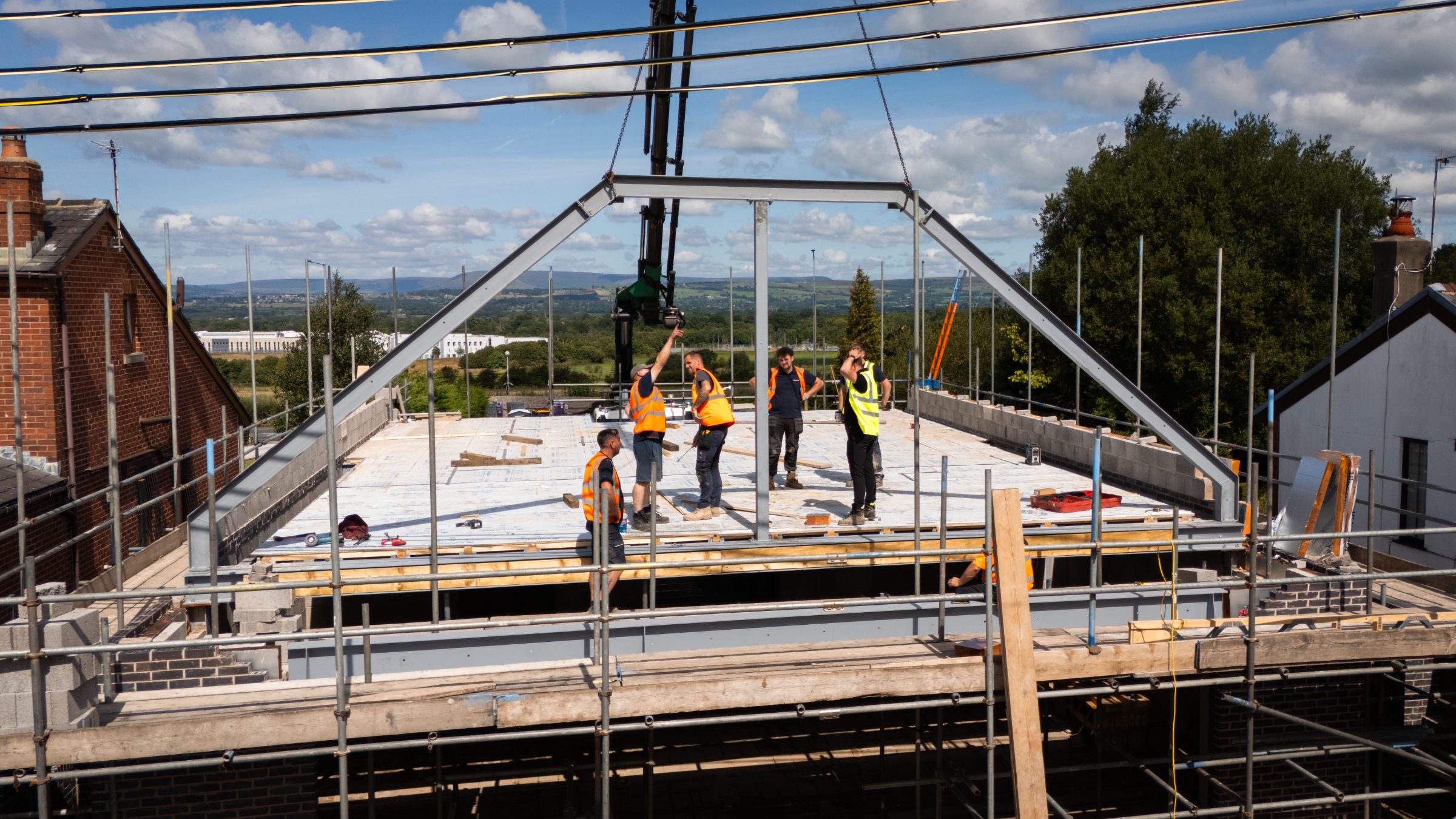Steel frame roof structure under construction with team on site — Artico